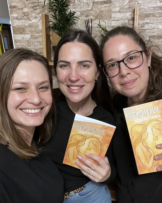 יוליה סטילוב עם שתי קוראות מחזיקות את הספר שקופה